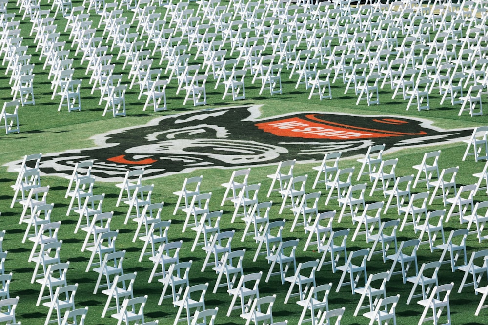 a race car driving through a large group of white chairs