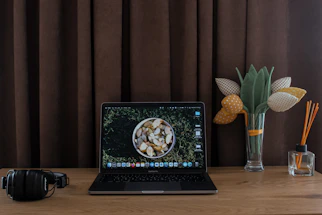 A cozy desk with a laptop, a bowl of crisps, and a notepad ready for messages.