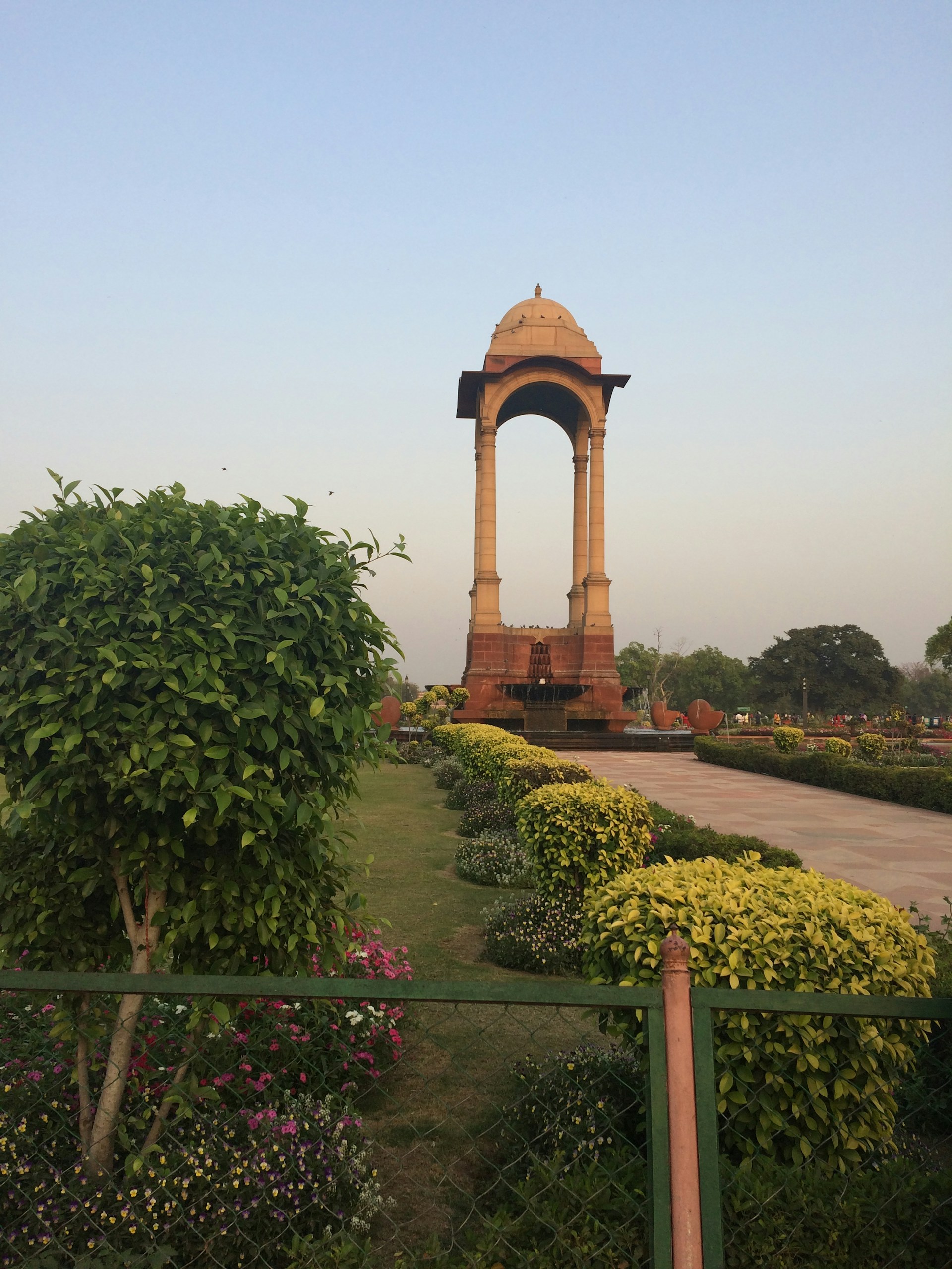 A wide shot of the clean and orderly layout of the memorial garden, showing the harmony between nature and sacred space under a clear blue sky.