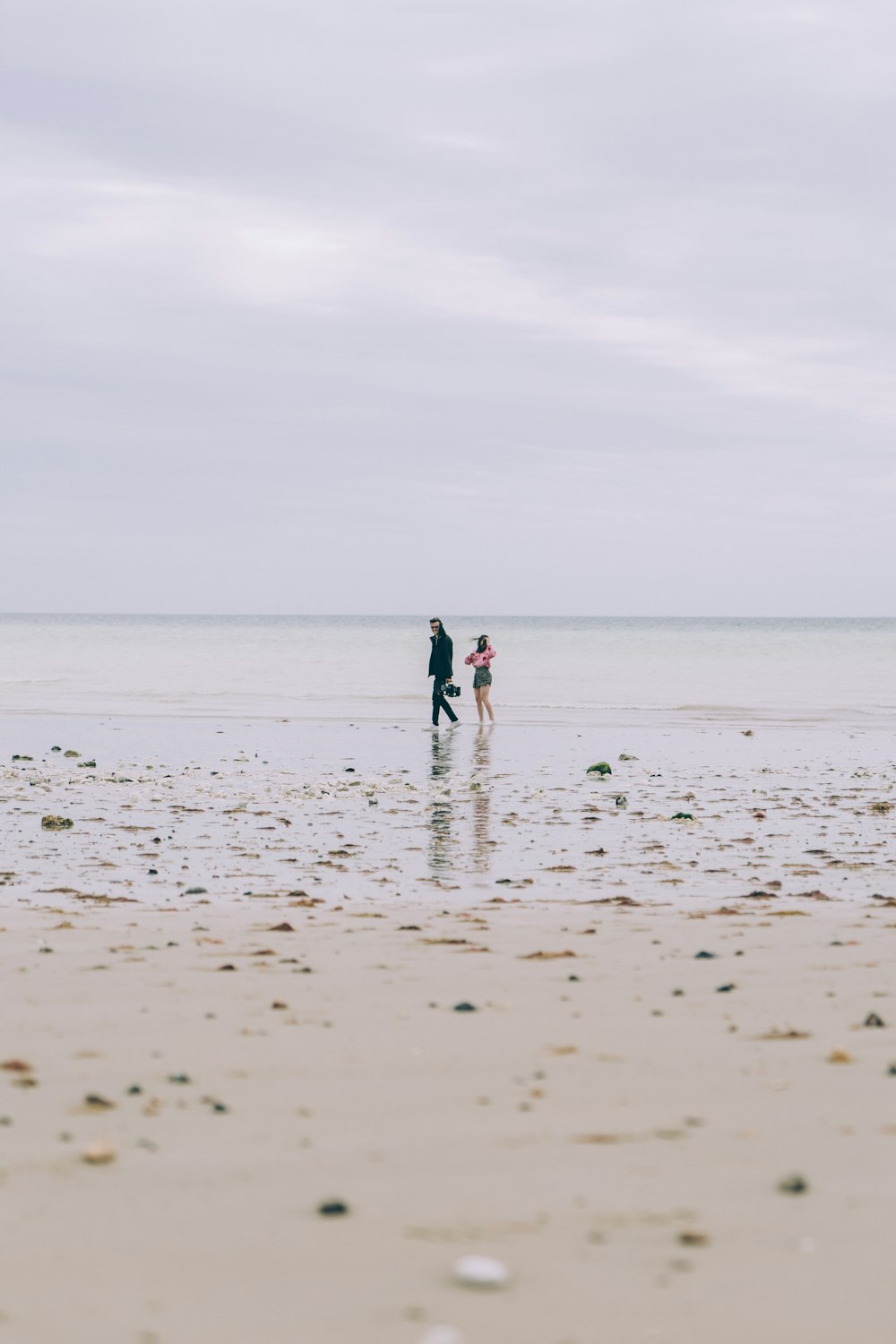 a couple people walking on a beach
