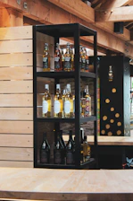Cozy interior of Spiritus Haven with wooden shelves lined with diverse whisky bottles and warm lighting.