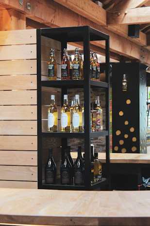 Cozy interior of Spiritus Haven with wooden shelves lined with diverse whisky bottles and warm lighting.