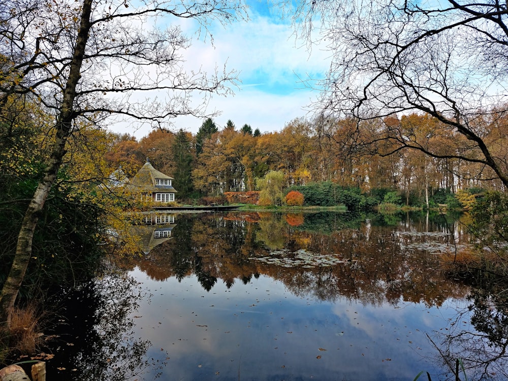 a lake surrounded by trees and a house