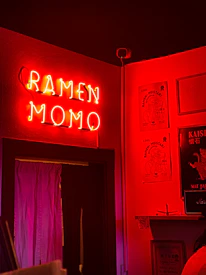 Cozy takeaway counter with deep maroon walls and white font signage of Kraze Momo.