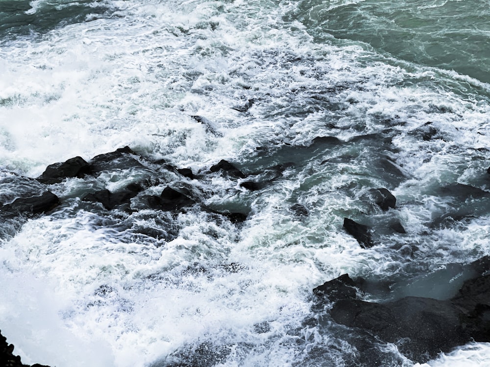 a body of water with rocks and waves