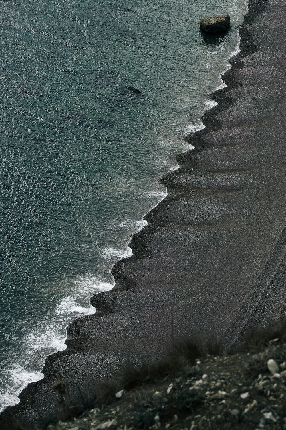una playa con rocas y un cuerpo de agua
