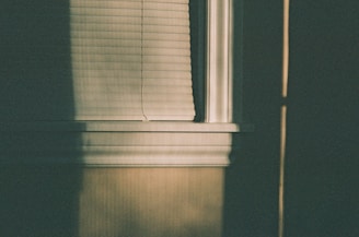 Bedroom with dark gray roller shades creating a calm and restful atmosphere.