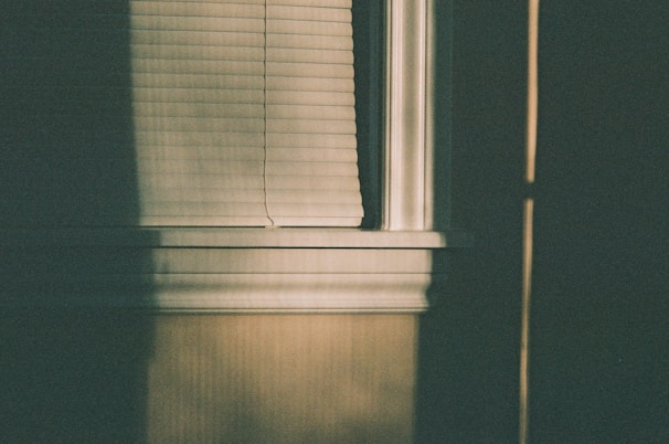 Bedroom with dark gray roller shades creating a calm and restful atmosphere.
