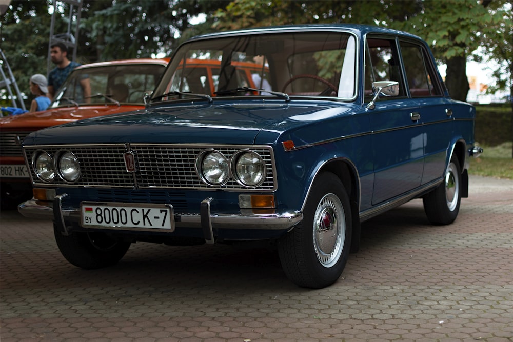 a blue car parked on a brick road