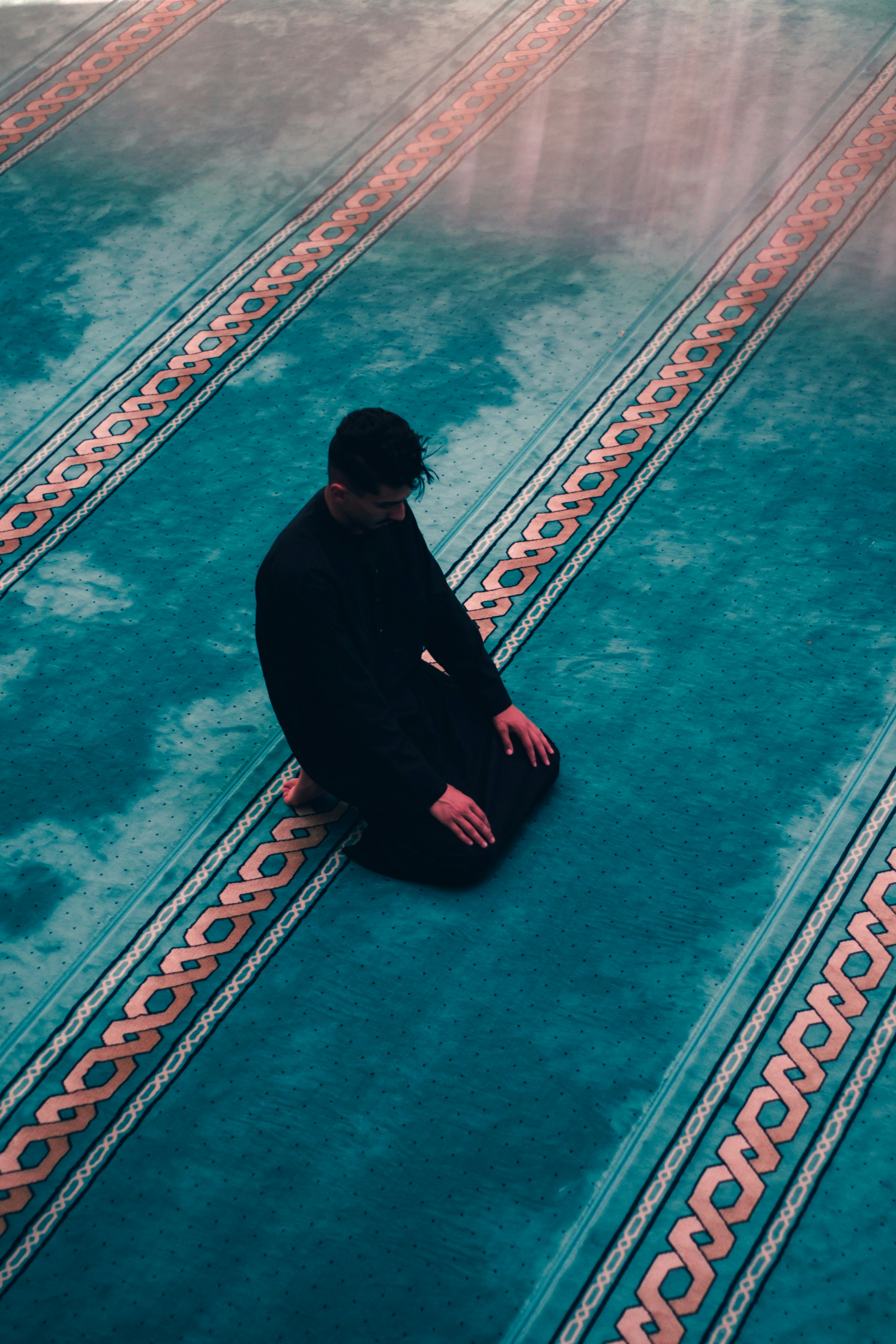 a man squatting on a sidewalk