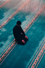 a man squatting on a sidewalk