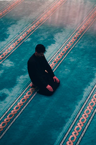 a man squatting on a sidewalk
