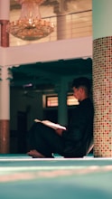 a man sitting on the floor reading a book