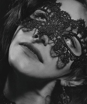 A close-up of a model's expressive eyes behind a delicate lace mask.
