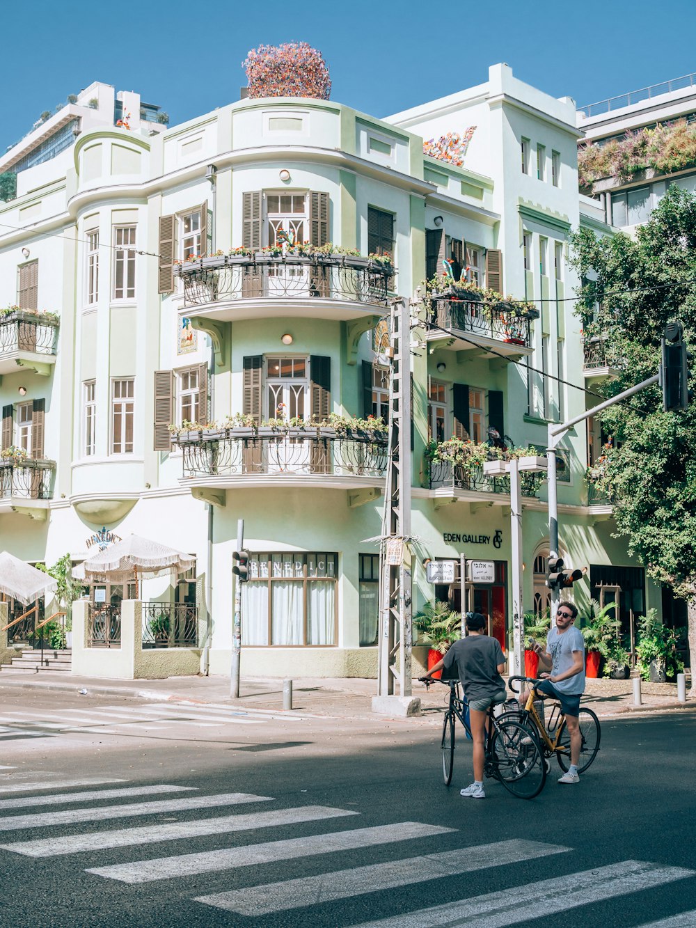 a couple of people riding bikes in front of a large white building