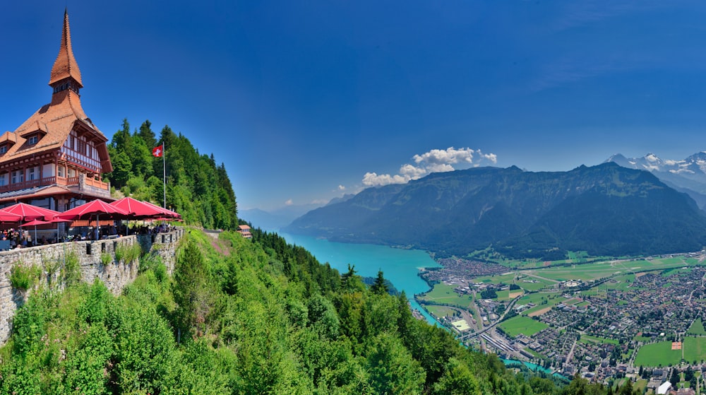 a building on a hill with a lake and mountains in the background