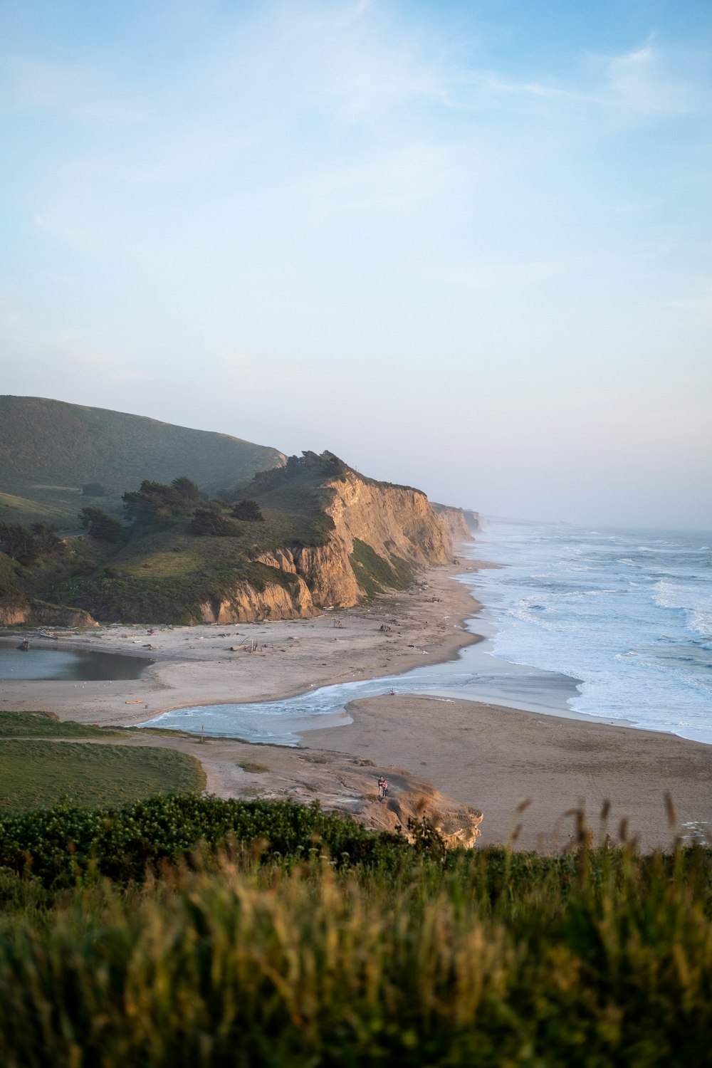 a beach with a hill in the background