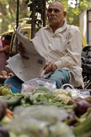 An elderly man reading a newspaper about economic and banking updates.
