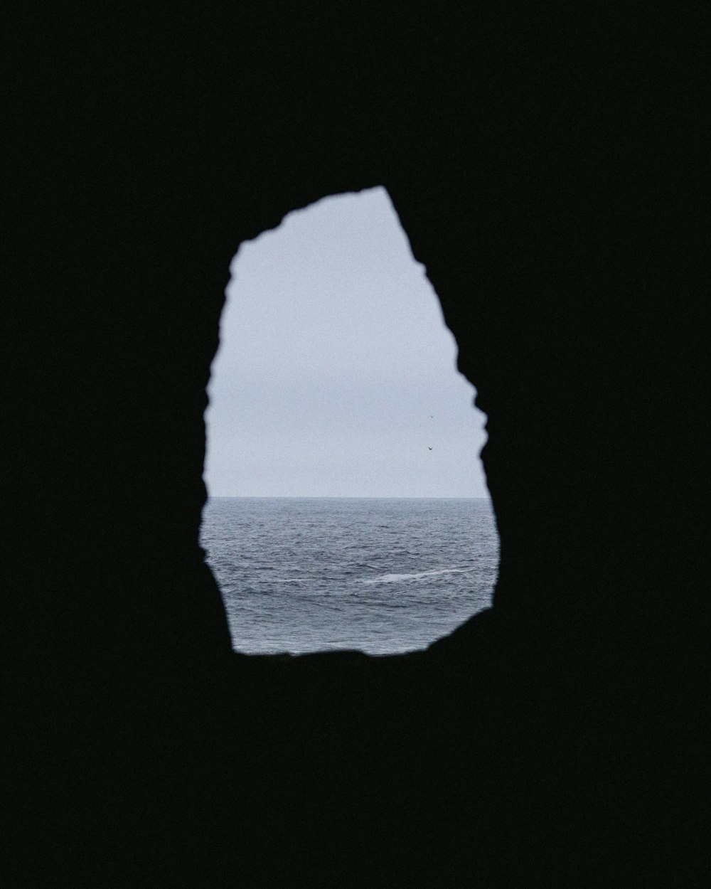 Una vista dell'oceano attraverso un buco in un muro