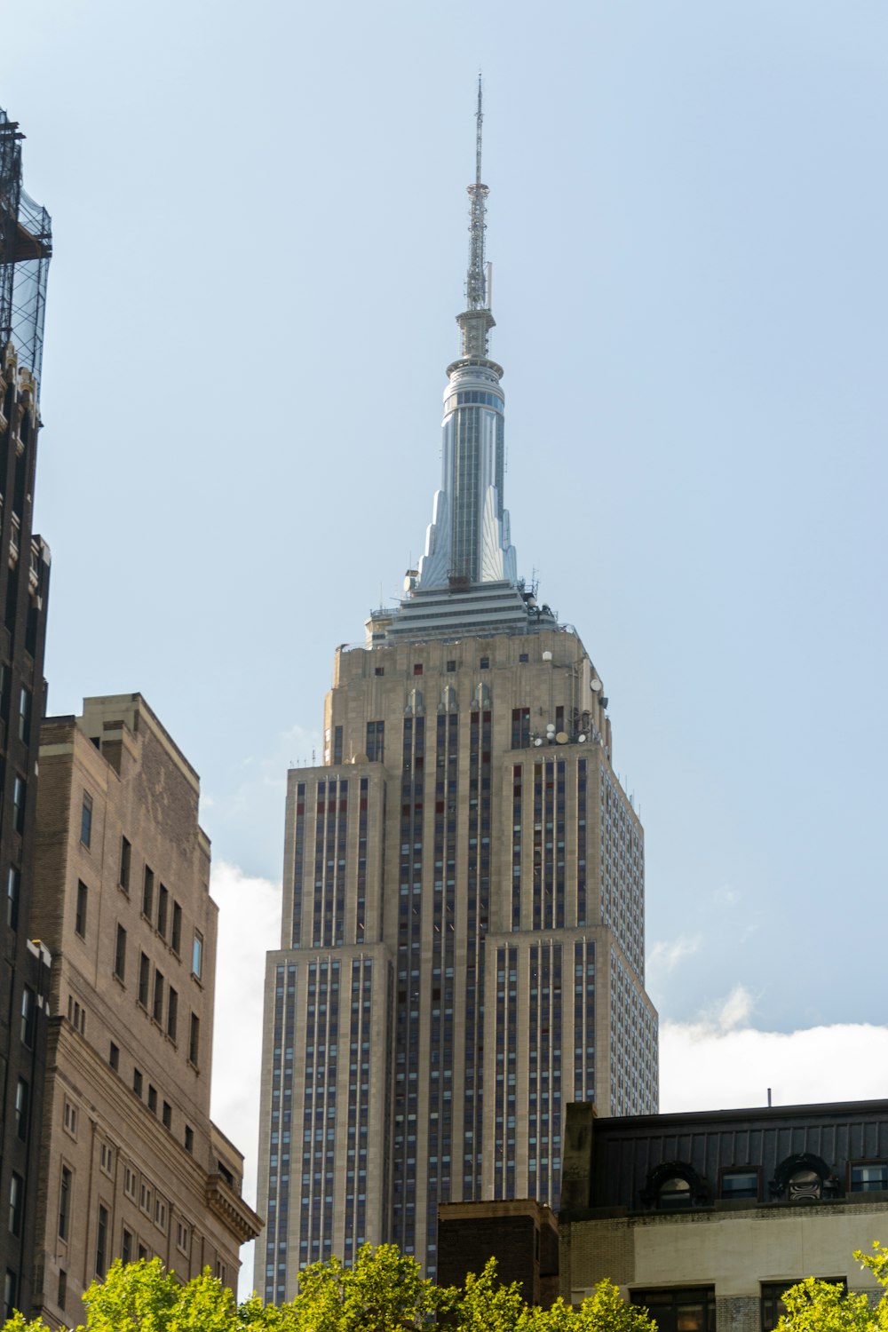 엠파이어 스테이트 빌딩을 배경으로 뾰족한 꼭대기가 있는 고층 건물