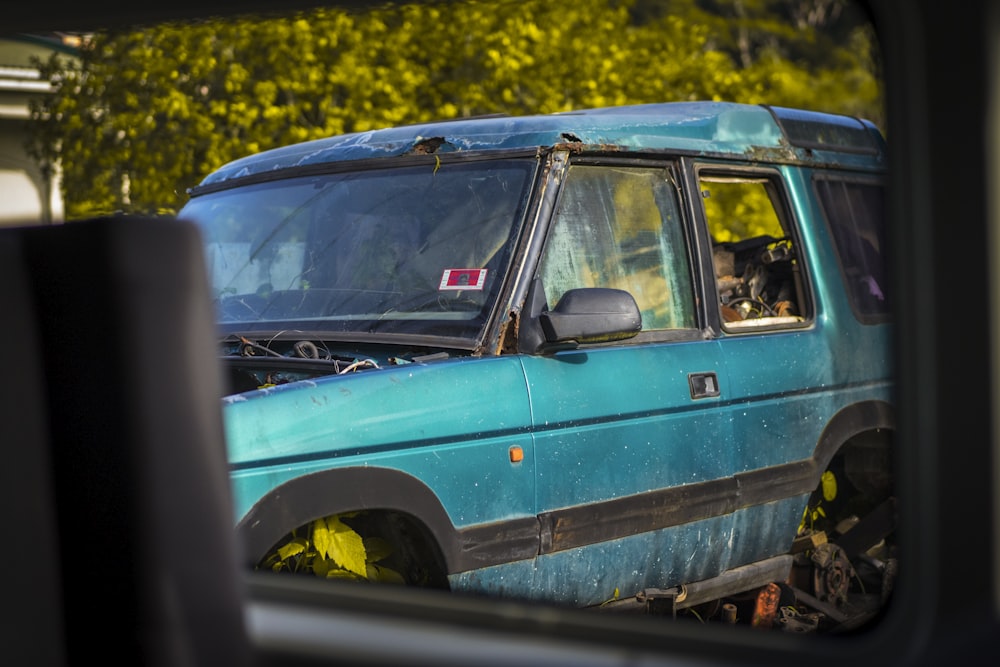 a blue car with a dog in the driver seat