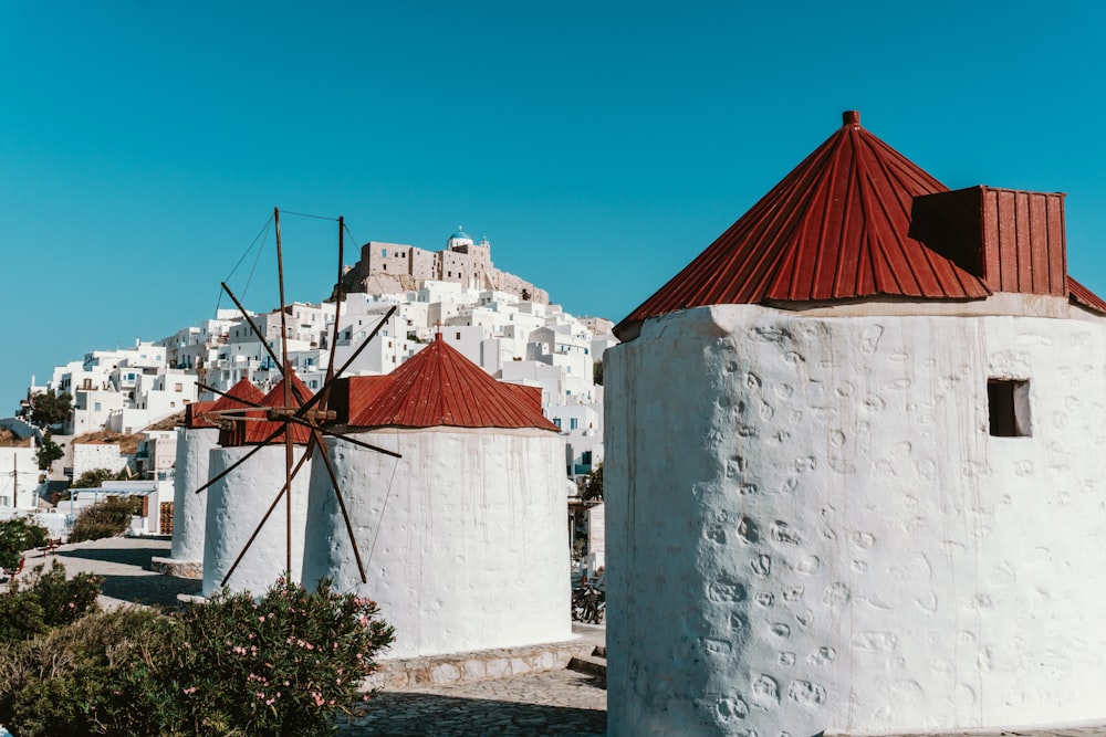 a group of white buildings with red roofs and a blue sky