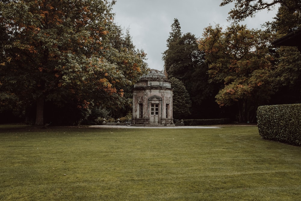 a building with a grass lawn and trees around it