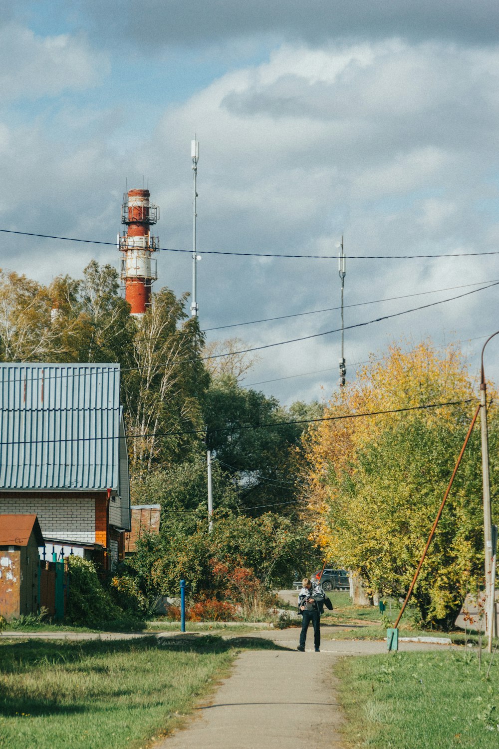 a group of people walking on a sidewalk next to a tower