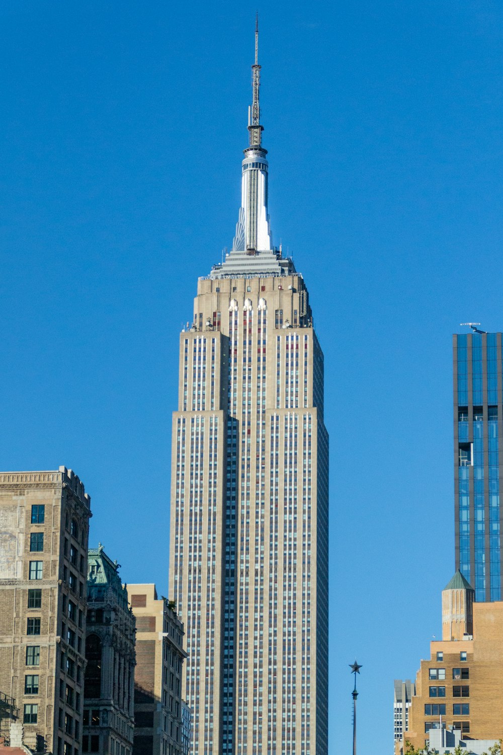 un edificio alto con una cima appuntita con Empire State Building sullo sfondo