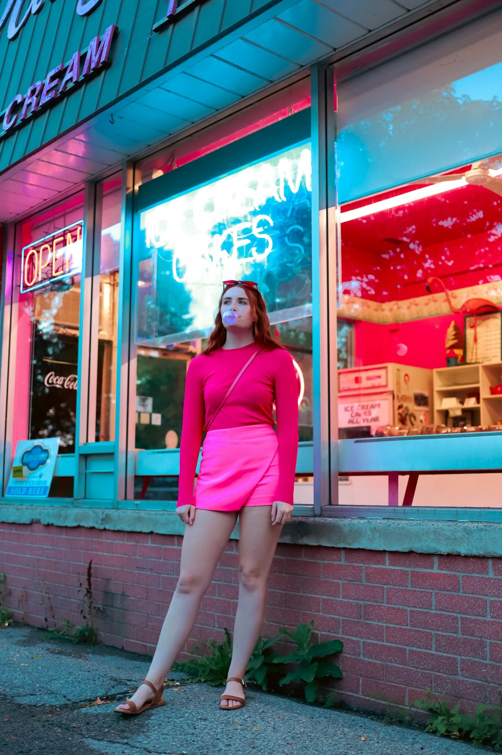 a woman posing in front of a storefront