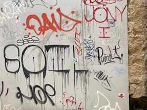 A gritty urban graffiti wall with bold colorful tags and a spray paint can resting nearby.