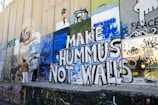 a group of people standing next to a wall covered in graffiti