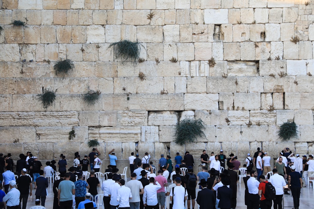 a group of people standing in front of a rock wall with Western Wall in the background