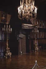 A warmly lit parlor room in the mansion showcasing period furniture and intricate woodwork.