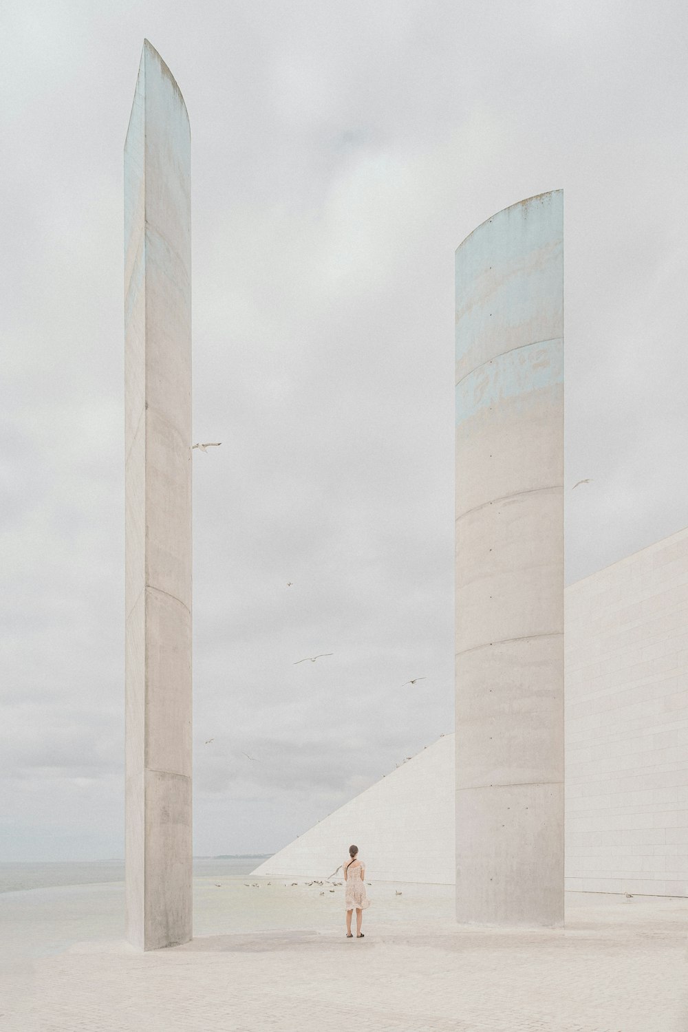 a person standing next to a couple of tall pillars