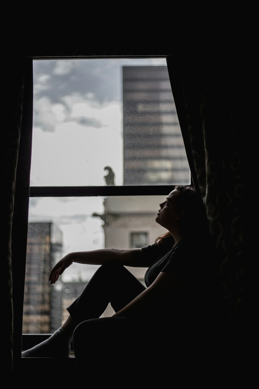 a person sitting on a window sill