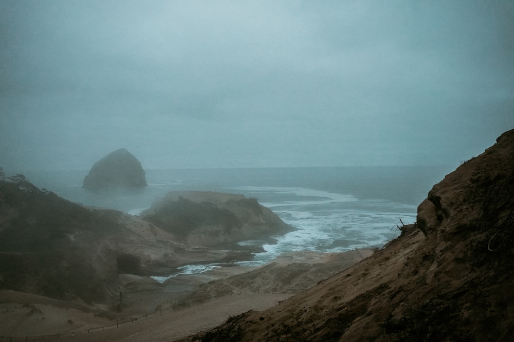 a rocky beach with a body of water in the distance