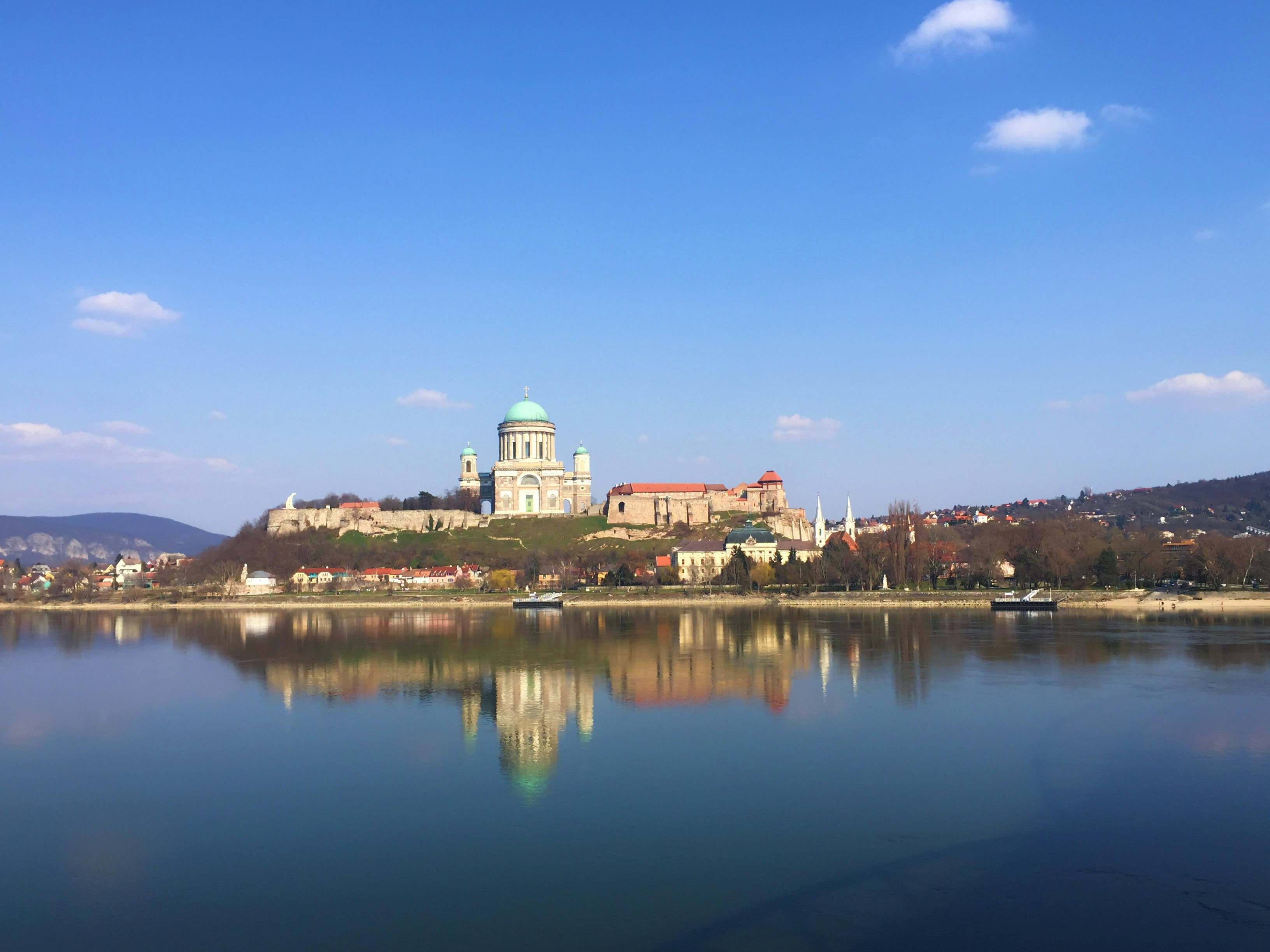 a body of water with buildings and trees in the background