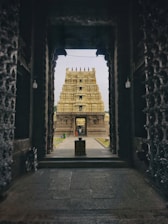 a stone archway with a building in the background