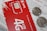 A close-up of a red SIM card holder from MTS with its accompanying packaging. The card displays '4G LTE' and includes a microchip design. Two coins are placed on top of a printed document, partially obscuring the text in Russian.