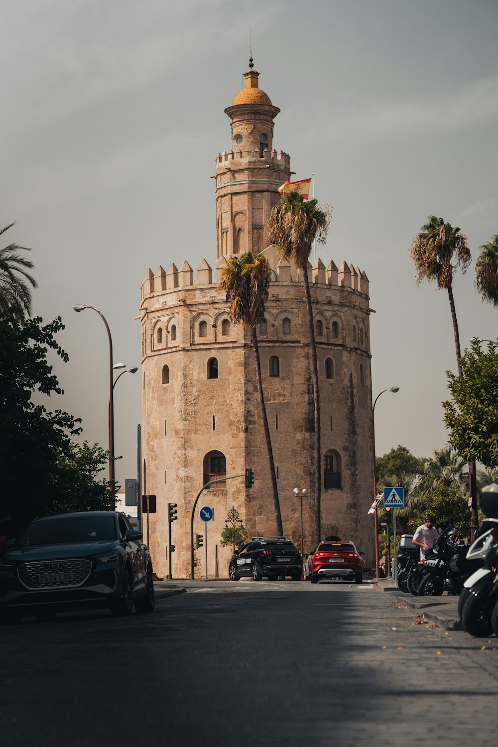 a large stone building with a gold domed roof and a gold domed roof with Torre del Oro in the background