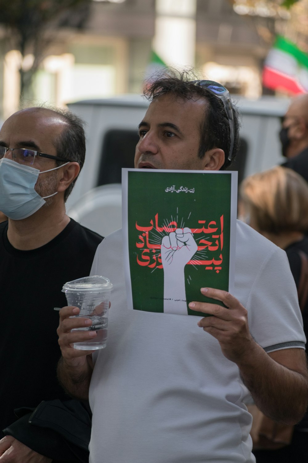 a man holding a cup and a paper with a cartoon character on it