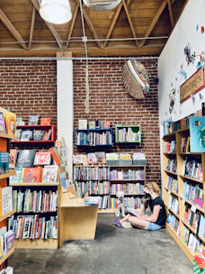 Volunteers reading books to children in a cozy community space.