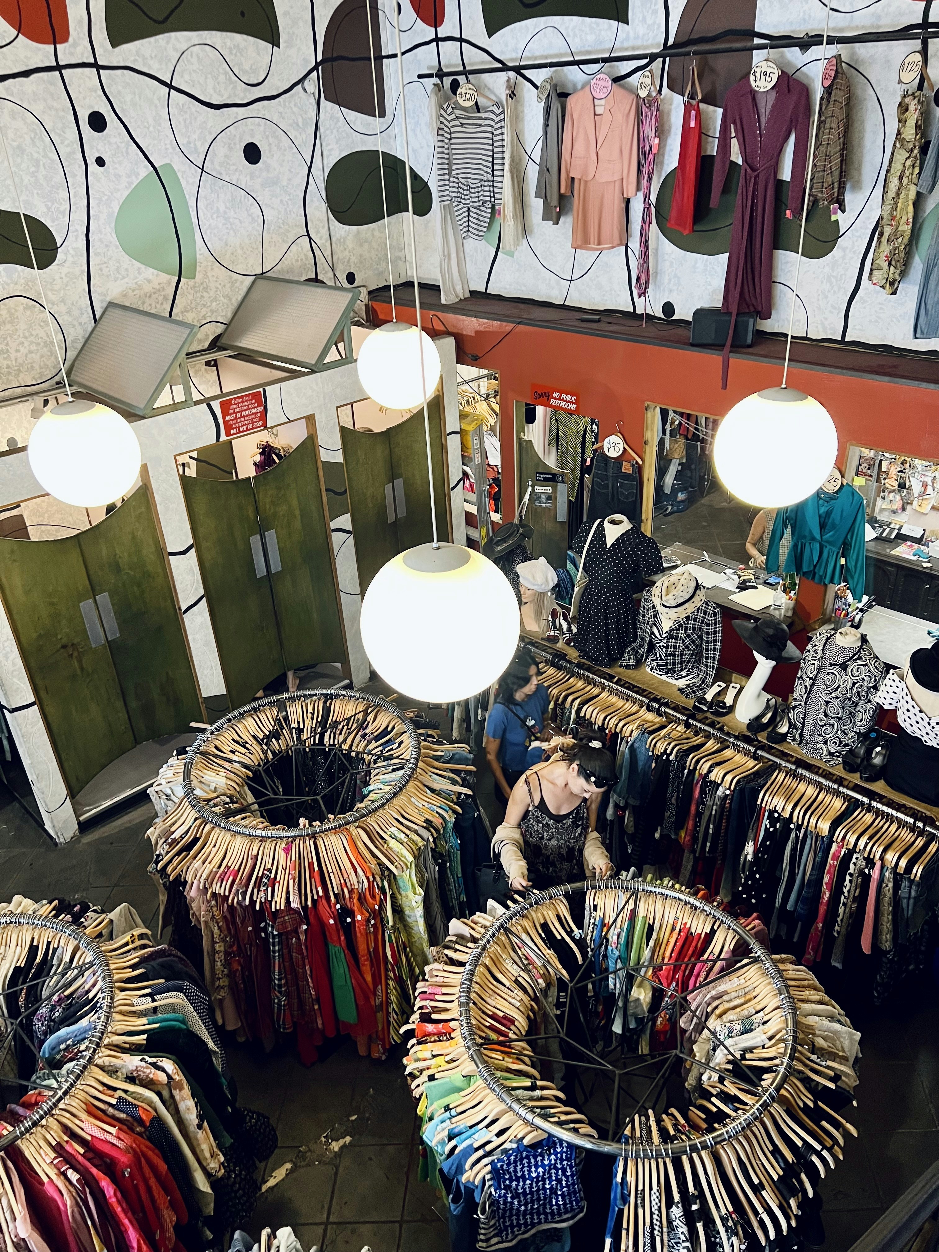 Vintage clothing rack in second-hand store, colorful garments from different eras