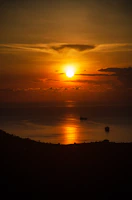 Sunset over the Panama Canal with ships passing through.