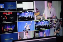 A multi-screen display showing various camera angles and views of a music or worship event. The screens include a live audience, performers on a stage, close-ups of a drummer, and a person speaking or singing. There are also overlay texts with labels such as 'ISO REC', 'Preview', and different camera numbers.