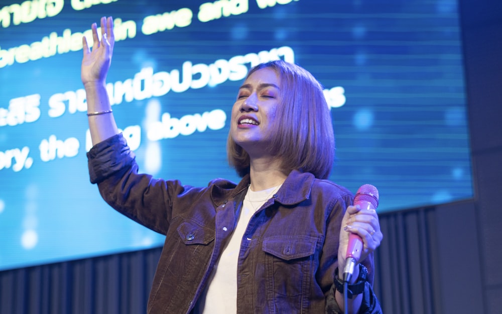 a person holding a microphone and raising the hands