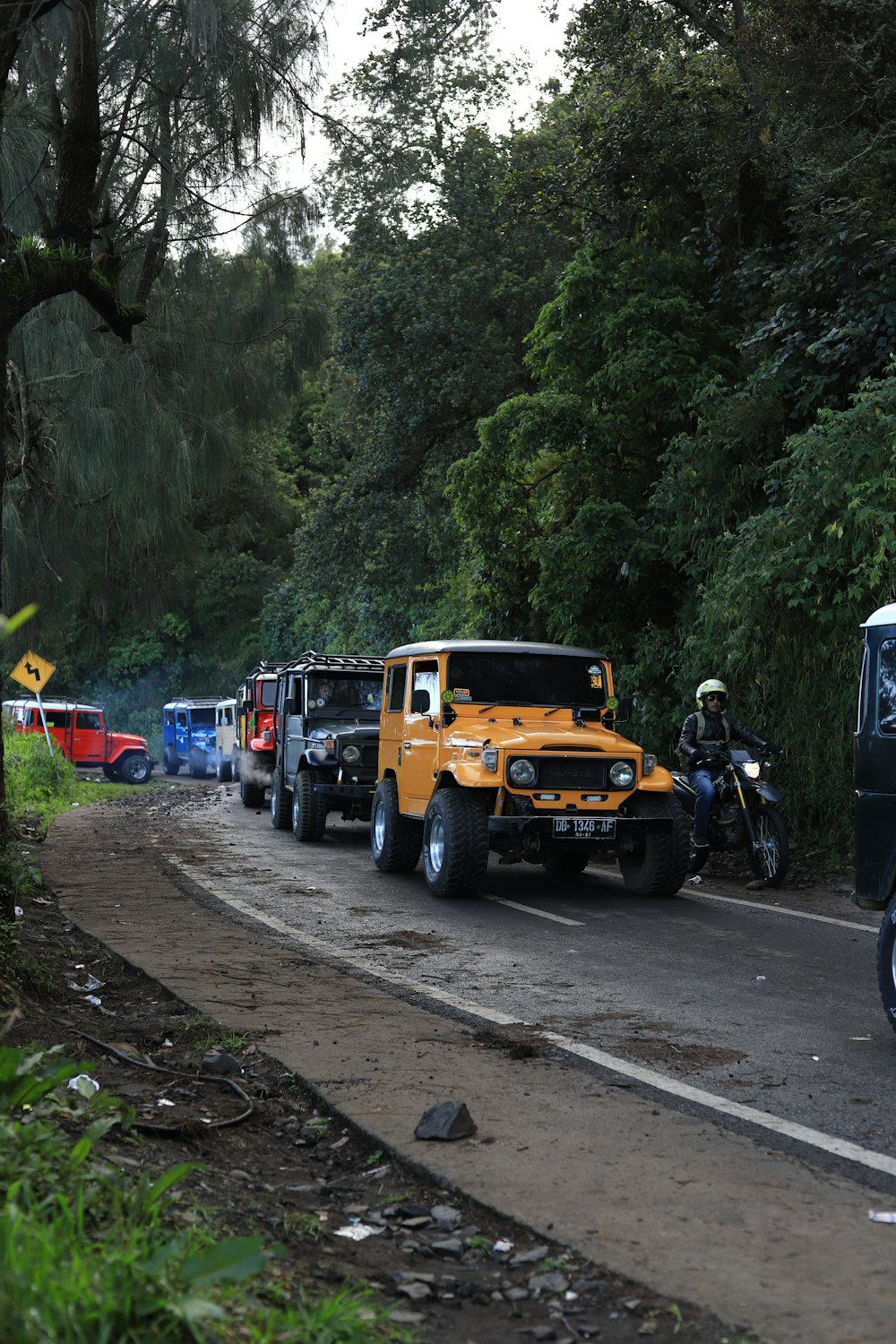 a person on a motorcycle next to a yellow truck