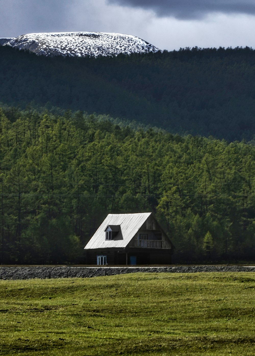 a house in a field with a mountain in the background