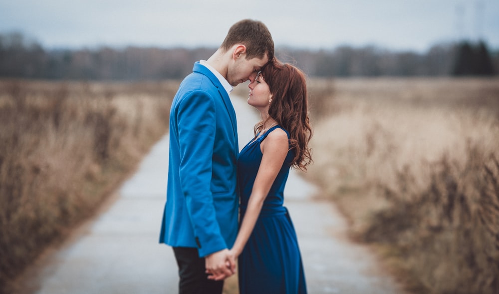 a man and woman kissing in a field of wheat